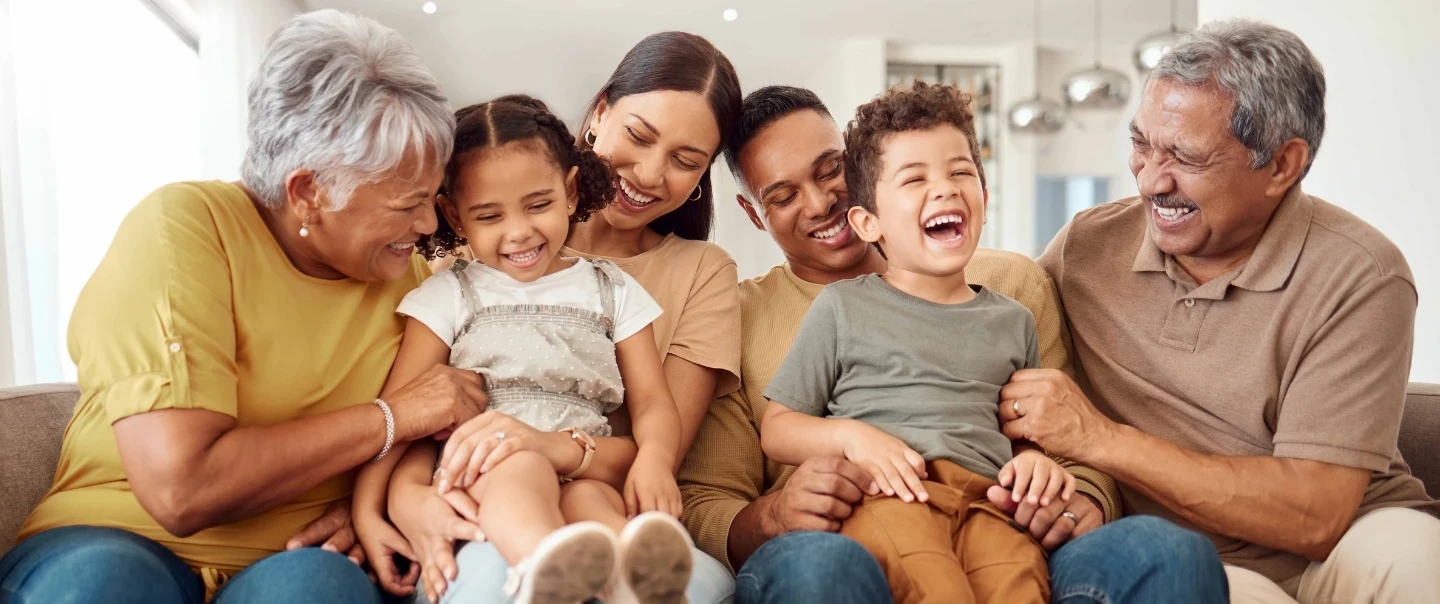 Multigenerational family laughing sitting together on couch