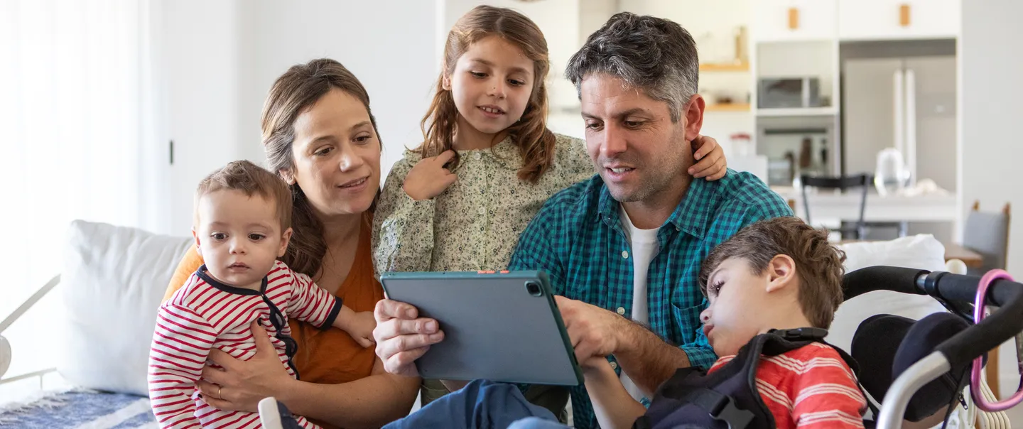  Portrait of parents with three small children using technology at home