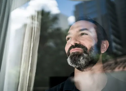 Man looking hopeful out window