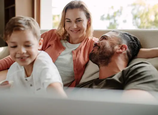 Happy young family relaxing on couch at home.