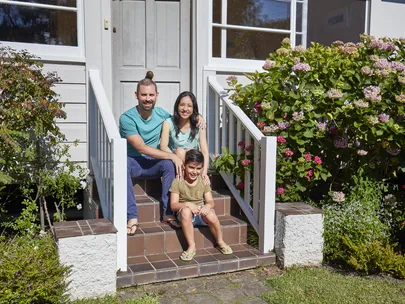 family sitting outside house
